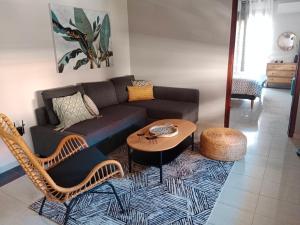 卡兰巴卡Central Lodge的客厅里有一张沙发、一张桌子和几把椅子。