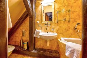 uma casa de banho com um lavatório, um espelho e uma banheira em Betlem Club Hotel em Praga