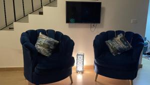 Duas cadeiras sentadas numa sala de estar com televisão em فيلا في بلو باي أسيا العين السخنة em Ain Sokhna