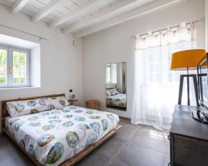 Schlafzimmer mit einem Bett, einer Kommode und einem Spiegel in der Unterkunft Contessa Pace - Luxury flat in Selvino