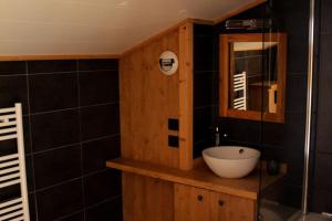 La salle de bains est pourvue d'un lavabo et d'un miroir. dans l'établissement Stijlvol 4-kamerappartement in Valmorel aan de piste, à Valmorel