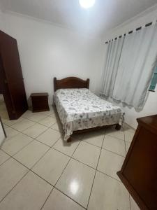 una piccola camera da letto con un letto in una stanza di Trilha do Mar 207 ad Arraial do Cabo