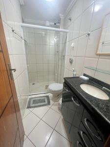 un bagno con doccia, lavandino e WC di Trilha do Mar 207 ad Arraial do Cabo Altre 10 foto