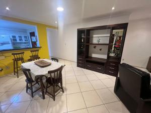 un soggiorno con un tavolo e una TV di Trilha do Mar 207 ad Arraial do Cabo