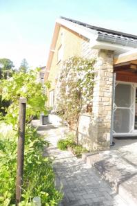 a brick house with a sidewalk next to a building at La Lustinoise in Lustin