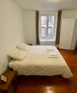 a white bed in a room with a window at Charmant appartement Rouen centre in Rouen