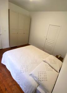 a bedroom with a large white bed with two pillows at Charmant appartement Rouen centre in Rouen