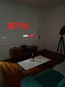 a living room with a netflix sign on the wall at Charmant appartement Rouen centre in Rouen