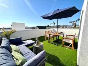 patio con divano e tavolo con ombrellone di Luxury K-Town Dwelling with private rooftop deck. a Los Angeles