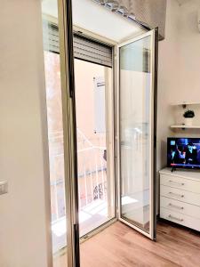 una puerta corredera de cristal en una habitación con TV en La Vacanzella al Gesu' Nuovo, en Nápoles