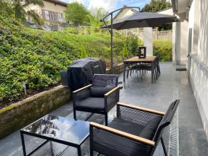 patio z krzesłami, stołem i parasolem w obiekcie Maison d architecte avec spa w Épernay
