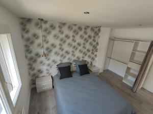 um quarto com uma cama com lençóis e almofadas azuis em Ty Breizh jet em Ergué-Gabéric