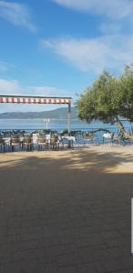 a group of tables and chairs on the beach at Apartmani Kate in Klek