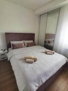 a large white bed with two towels on it at VIP Apartment in Jagodina