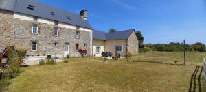 a large stone building with a yard in front of it at L' Anpeg, gîte dans le Cotentin jusqu'à 8 personnes in Besneville