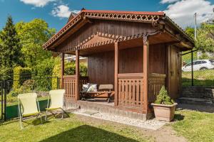 un gazebo in legno in un cortile con due sedie di Willa Szarotka B&B a Szczawnica