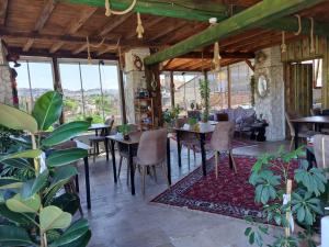 uma sala de jantar com mesas, cadeiras e janelas em Duru Cappadocia Stone House em Nevşehir