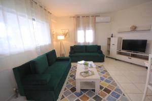 a living room with a green couch and a table at Olga's Home(Σπίτι με θέα δίπλα στην θάλασσα) in Kritharia