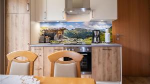 a kitchen with a painting on the wall at Appartement Alexandra in Neukirchen am Großvenediger