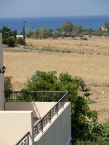 einen Balkon eines Hauses mit Blick auf ein Feld in der Unterkunft Latchi Studio Apartment in Polis Chrysochous