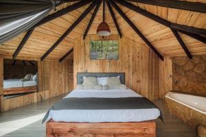 um quarto com uma cama e uma banheira num quarto em Hotel & Spa Escondite de la Montaña em Sabana Redonda