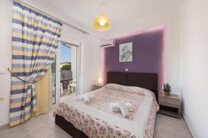 a bedroom with a bed with a purple wall at Savvas Apartment in Afantou