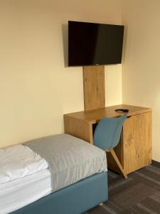a bedroom with a bed and a desk with a television at ADANIA 1 in Grzybowo