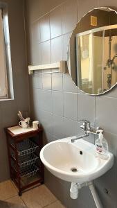 uma casa de banho com um lavatório branco e um espelho. em Pokoje U Hanki em Dziwnów