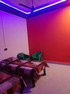 een kamer met 2 bedden en een rode muur bij Krishna Kunj Homestay Rishikesh in Rishīkesh