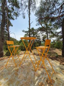 deux tables et chaises orange assises au sol dans l'établissement La calade, à Bargème