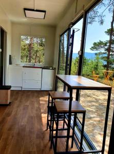 uma cozinha com mesa e cadeiras num quarto com janelas em La calade em Bargème