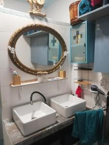 un bagno con 2 lavandini bianchi e uno specchio di vacance espagne a Llaurí