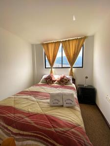 1 dormitorio con 1 cama con 2 almohadas y ventana en Hostal La Terraza en Quito