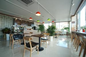 a restaurant with tables and chairs in a room at Seongsan Aqua Beach Hotel in Seogwipo