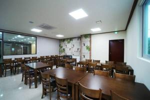 a dining room with wooden tables and chairs at Seongsan Aqua Beach Hotel in Seogwipo