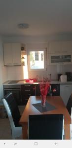 a kitchen with a wooden table with chairs and a vase on it at Apartmani Kate in Klek +15 photos