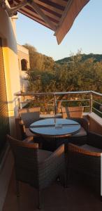 a patio with a table and chairs on a balcony at Apartmani Kate in Klek