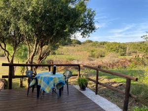 einen Tisch und Stühle auf einer Holzterrasse in der Unterkunft Armonía in Villa Serrana