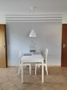 a white dining room with a white table and chairs at Ferienwohnung Hermann in Bovenden