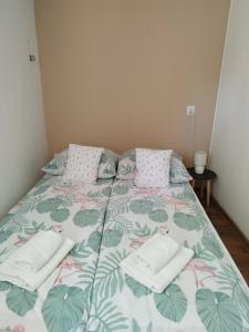 sypialnia z łóżkiem z zielonym i różowym kocem w obiekcie Noclegi u Marcela w mieście Ustrzyki Dolne
