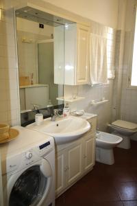ein Badezimmer mit einem Waschbecken und einer Waschmaschine in der Unterkunft BlancoHouse Viale Ceccarini in Riccione