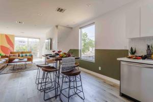 a kitchen and living room with stools and a counter at Hollywood Art House with Bright Sunlight in Los Angeles