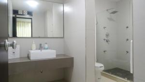ein Bad mit einem WC, einem Waschbecken und einer Dusche in der Unterkunft Suites San Luis in Mazatlán