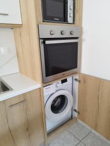 a kitchen with a microwave and a washing machine at Sun & Sea Apartments Plakias II in Plakias