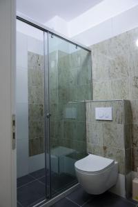 uma casa de banho com uma cabina de duche em vidro e um WC. em Fishta apartments Q5 32 em Velipoja