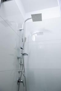 La salle de bains blanche est pourvue d'une douche et d'un lavabo. dans l'établissement Fishta apartments Q5 32, à Velipojë