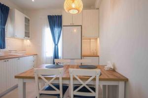 una cucina con tavolo in legno e sedie bianche di MFP Dryos Paros House Project a Drios