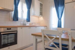 una cucina con tende blu e tavolo e sedie di MFP Dryos Paros House Project a Drios Altre 9 foto