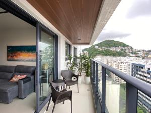 Un balcón con sofá y sillas. en Apartamento moderno completo, en Río de Janeiro