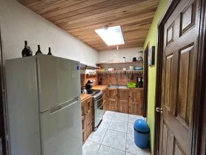 een grote keuken met houten kasten en een koelkast bij Alojamientos Norte y Sur in Monteverde Costa Rica